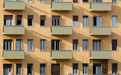 Fachada de edifício com janelas e varandas; fotografia ilustrativa para o tema de despesas condominiais.